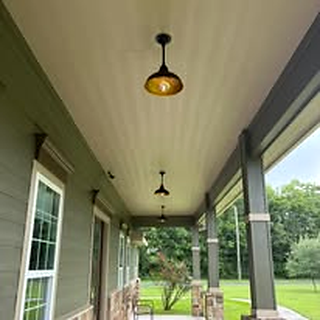 Row of new outdoor barn lights installed along a porch ceiling in La Porte TX